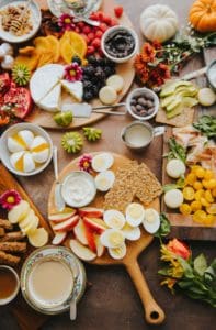 Flat lay of platters of food including small bowls with dips and olives