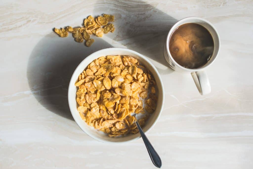 bowl of cornflakes and mug of coffee