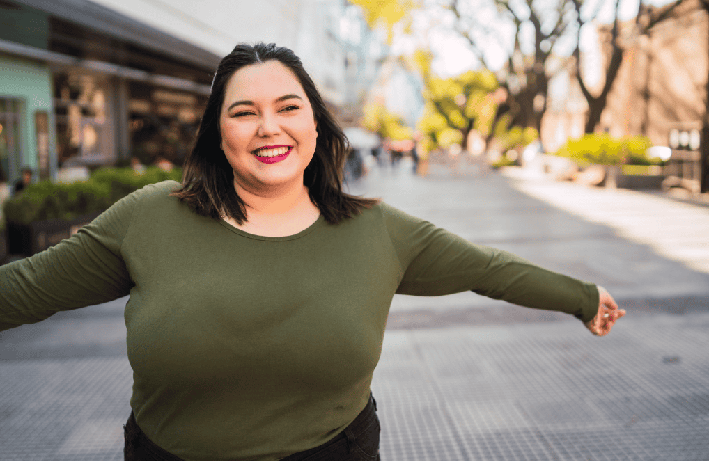 A woman smiling with her arms wide open 